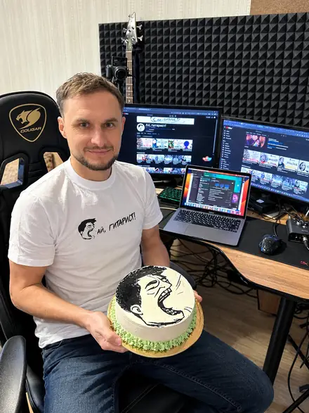 Андрей с тортом с логотипом «Ай, Гитарист!» за рабочим столом