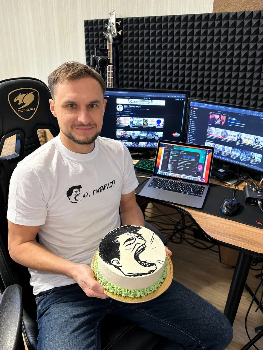 Андрей с тортом с логотипом „Ай, Гитарист!“ за рабочим столом